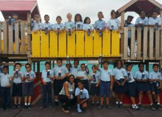 Miss Mature presents water bottles to students