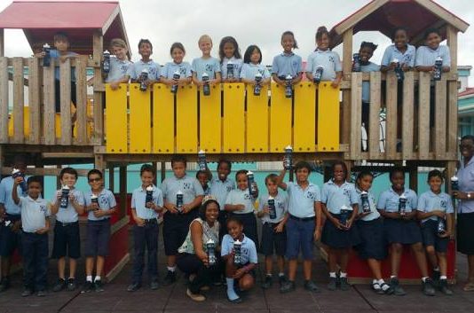 Miss Mature presents water bottles to students