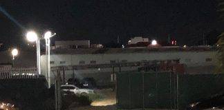 Shot fired at suspect caught breaking and entering a car dealership.