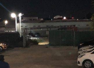 Shot fired at suspect caught breaking and entering a car dealership.