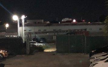 Shot fired at suspect caught breaking and entering a car dealership.