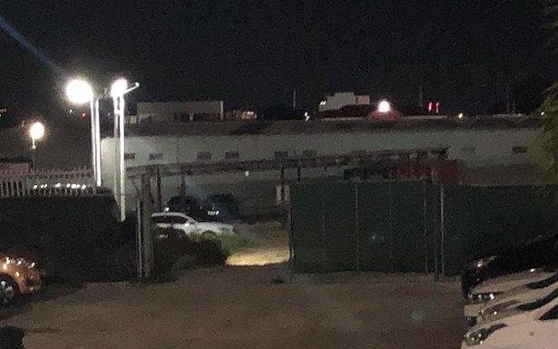 Shot fired at suspect caught breaking and entering a car dealership.