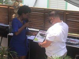 Former Minister Gordon-Carty presents copy of her book to USP Leader Frans Richardson
