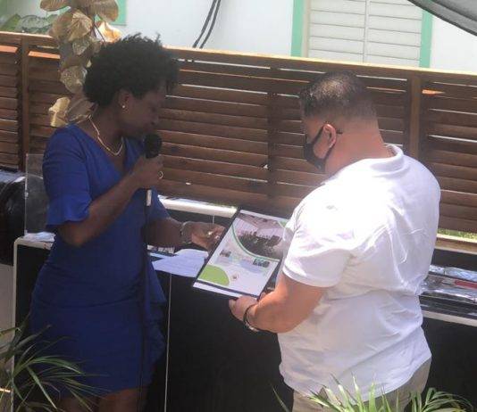 Former Minister Gordon-Carty presents copy of her book to USP Leader Frans Richardson