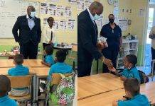 Minister Ottley distributes water and apples in honor of World Oral Health Day to the students of Marie Genevieve DeWeever school