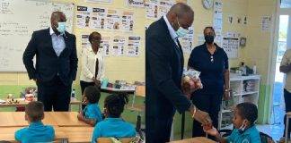 Minister Ottley distributes water and apples in honor of World Oral Health Day to the students of Marie Genevieve DeWeever school