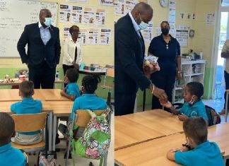 Minister Ottley distributes water and apples in honor of World Oral Health Day to the students of Marie Genevieve DeWeever school