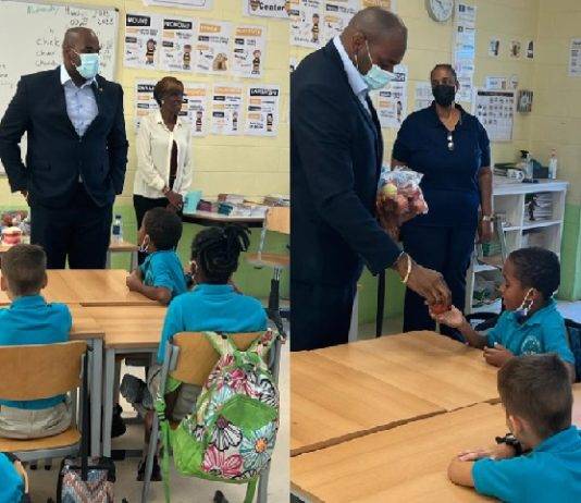 Minister Ottley distributes water and apples in honor of World Oral Health Day to the students of Marie Genevieve DeWeever school