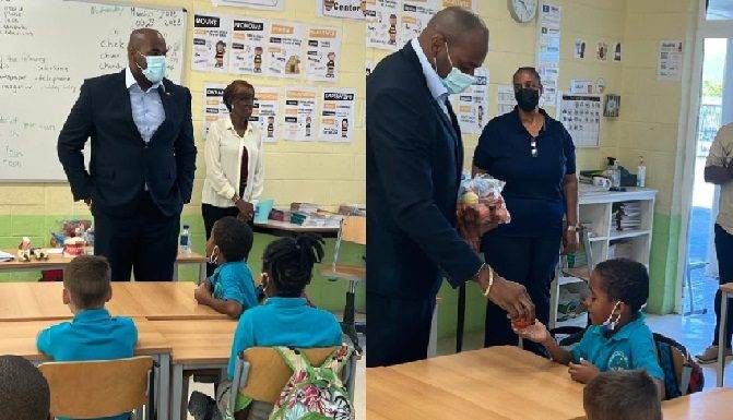 Minister Ottley distributes water and apples in honor of World Oral Health Day to the students of Marie Genevieve DeWeever school