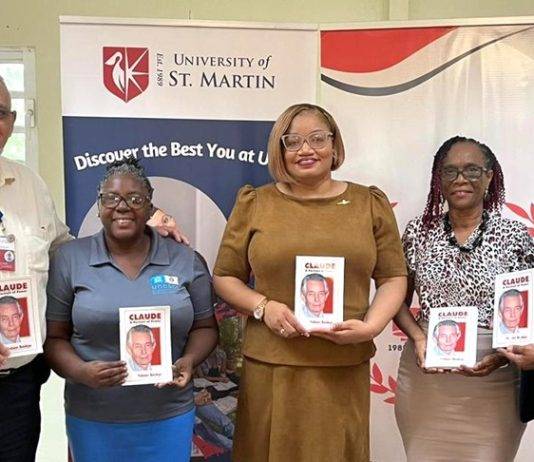Minister Marinka Gumbs Presents USM with book on Claude to mark his 98th birthday
